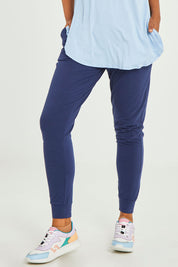 Model Olivia wearing size 10 of the Heidi Pant in colour Navy (Blue), from the front, cropped image