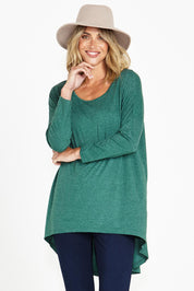 A model wearing the Celeste Tunic Tee in colour Greenmarle (Green), from the front, cropped image