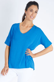Model Gemma wearing size 10 of the Lisbon Tee in colour Cornflower (Blue), from the front, cropped image