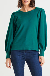 A model wearing the Charlotte Knit Jumper in colour Teal (Green), from the front, cropped image