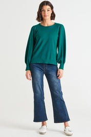 A model wearing the Charlotte Knit Jumper in colour Teal (Green), from the front, showing the whole outfit