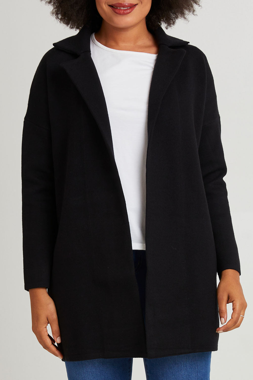 Model Olivia wearing size 10 of the Bristol Coatigan in colour Black (Black), from the front, cropped image