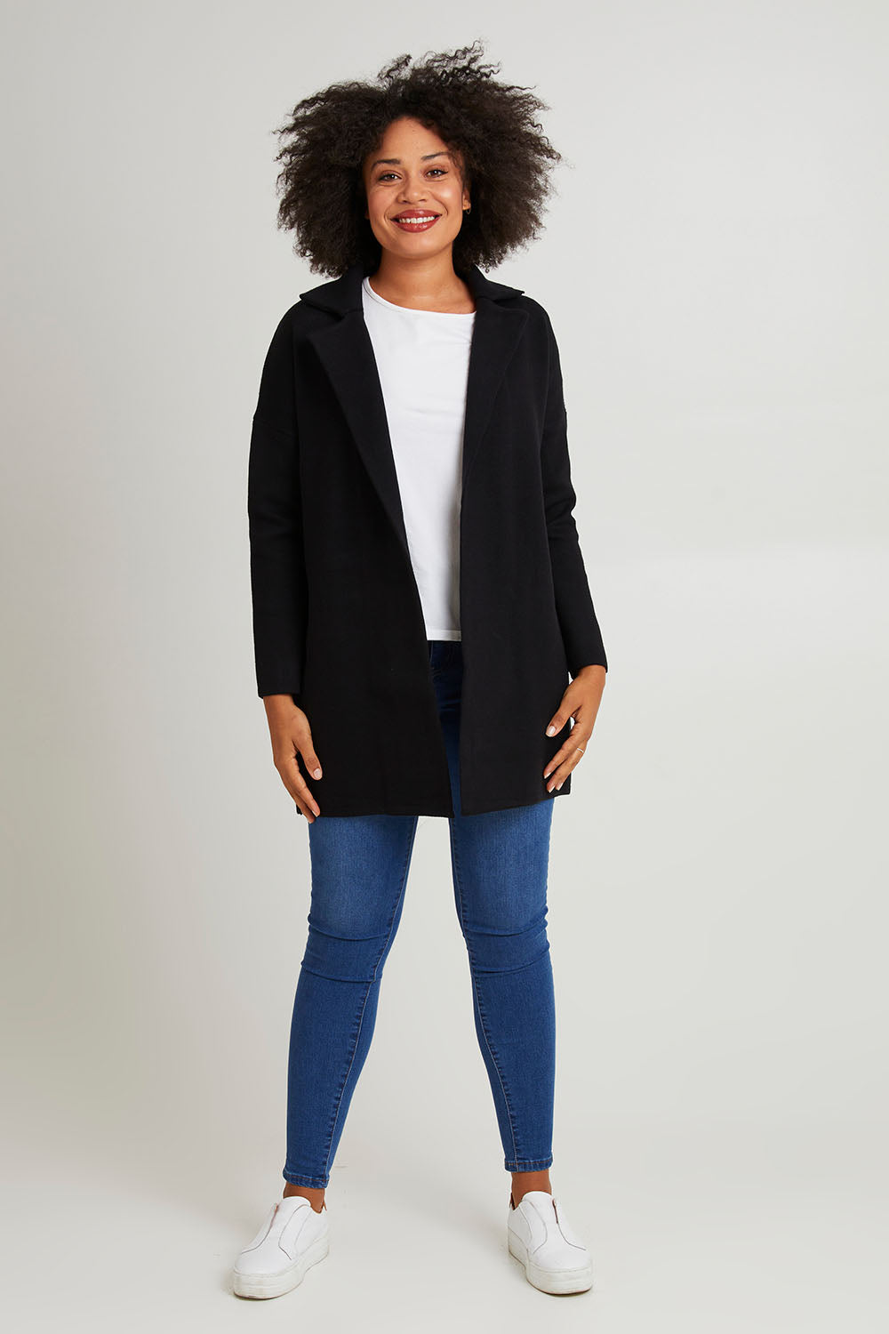 Model Olivia wearing size 10 of the Bristol Coatigan in colour Black (Black), from the front, showing the whole outfit
