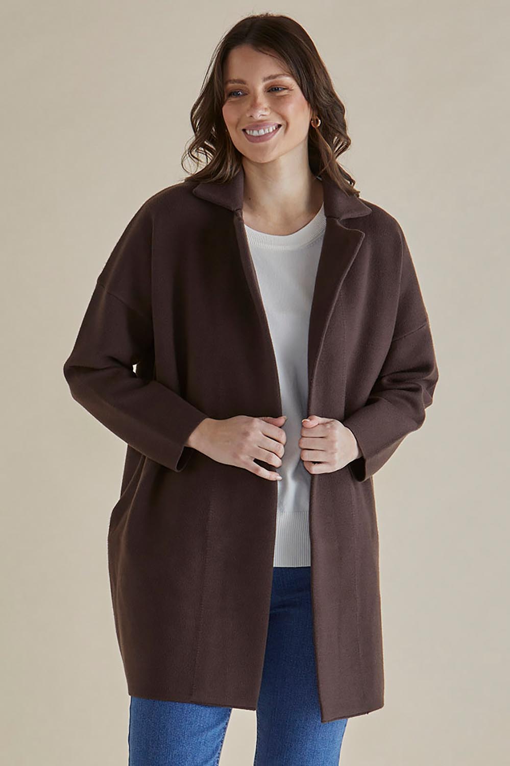 A model wearing the Bristol Coatigan in colour Brown, from the front, cropped image
