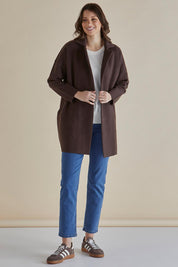 A model wearing the Bristol Coatigan in colour Brown, from the front, showing the whole outfit