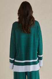A model wearing the Eleanor Knit Jumper in colour Basil (Green), from the back