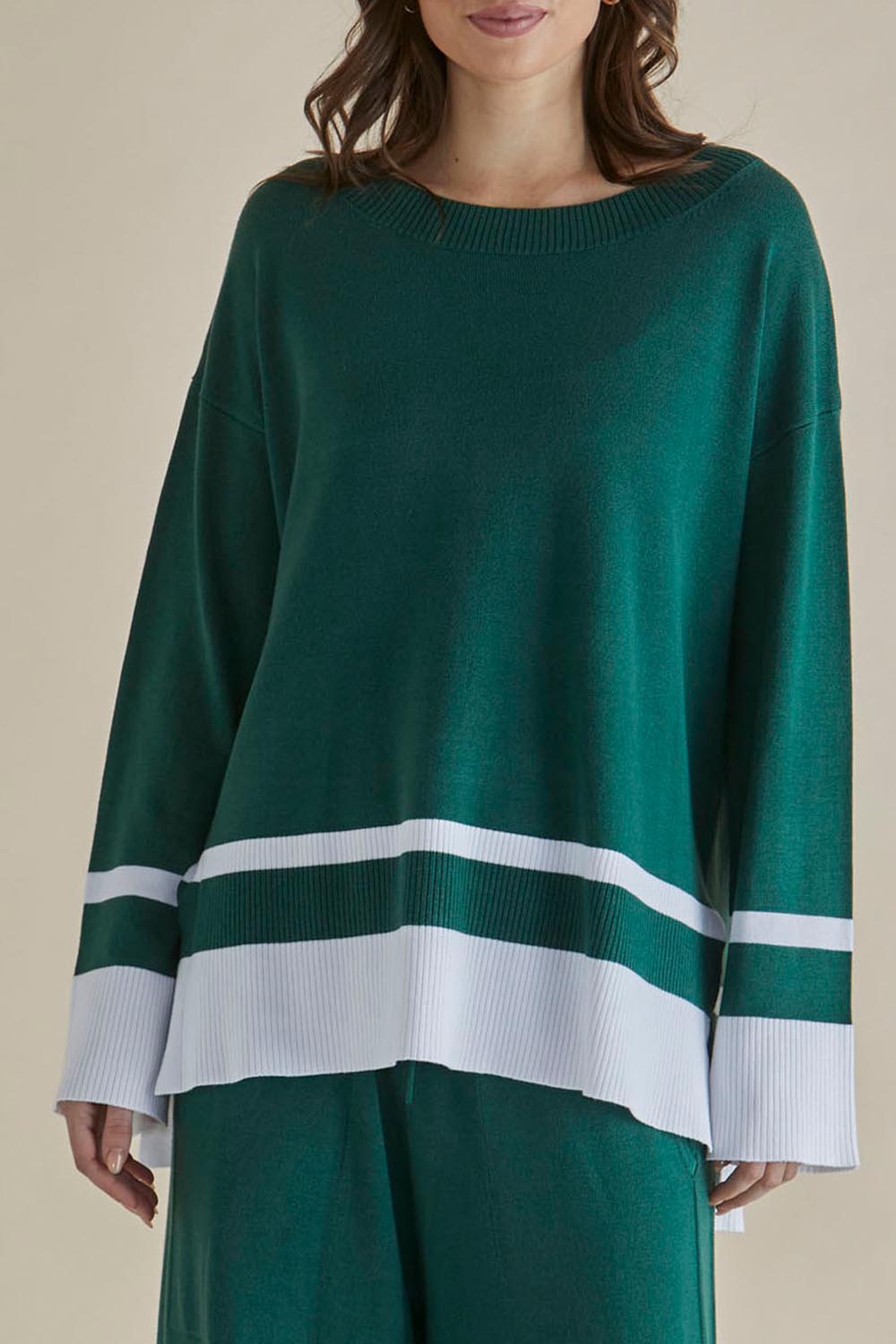 A model wearing the Eleanor Knit Jumper in colour Basil (Green), from the front, cropped image