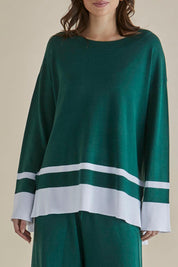 A model wearing the Eleanor Knit Jumper in colour Basil (Green), from the front, cropped image