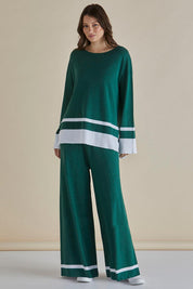 A model wearing the Eleanor Knit Jumper in colour Basil (Green), from the front, showing the whole outfit