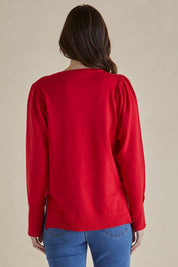 A model wearing the Colette Sweater in colour Red (Red), from the back