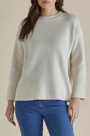 A model wearing the Edith Knit Jumper in colour Cream (White), from the front, cropped image