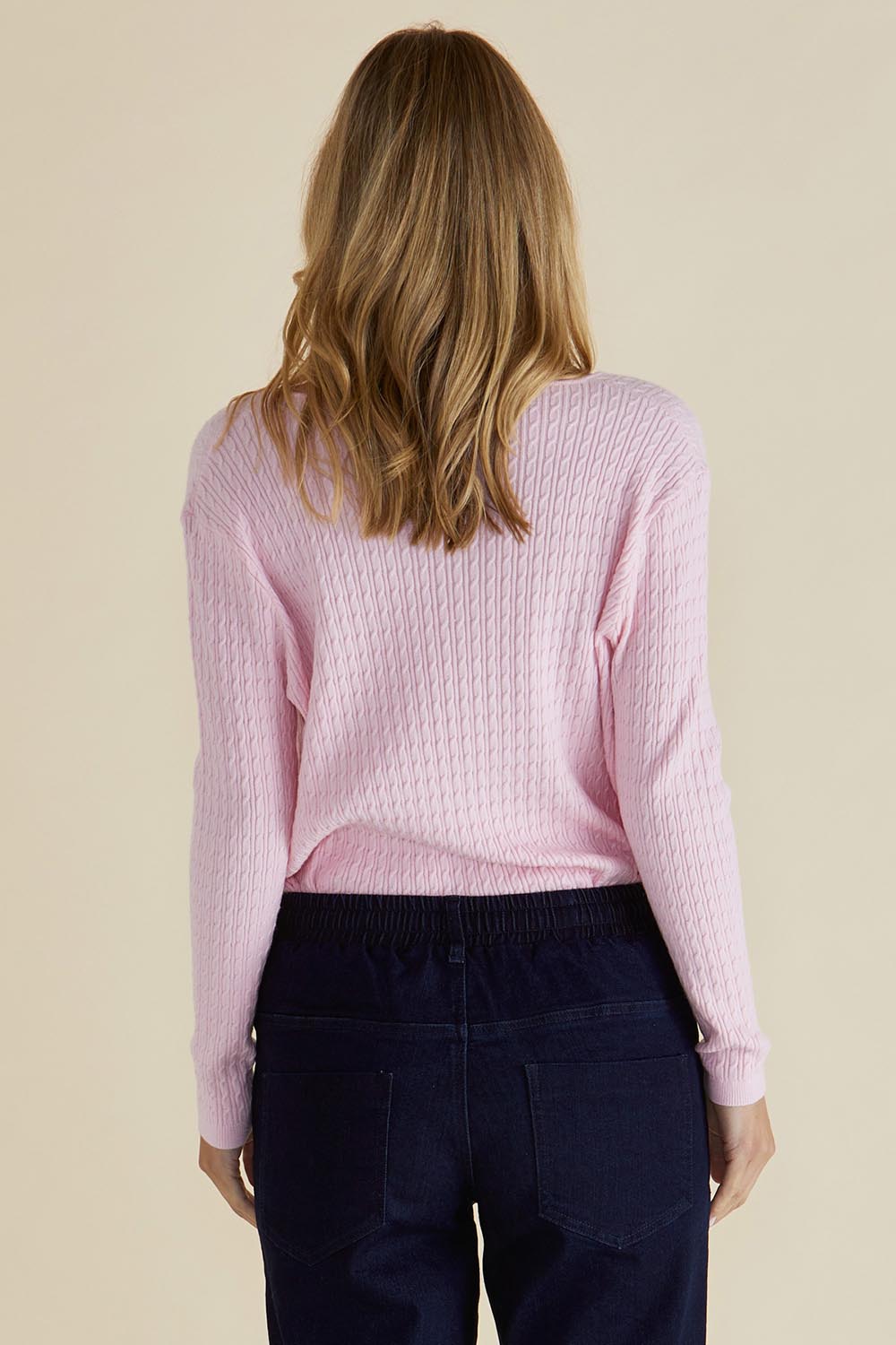 A model wearing the Cable Mini Jumper in colour Babypink (Pink), from the back