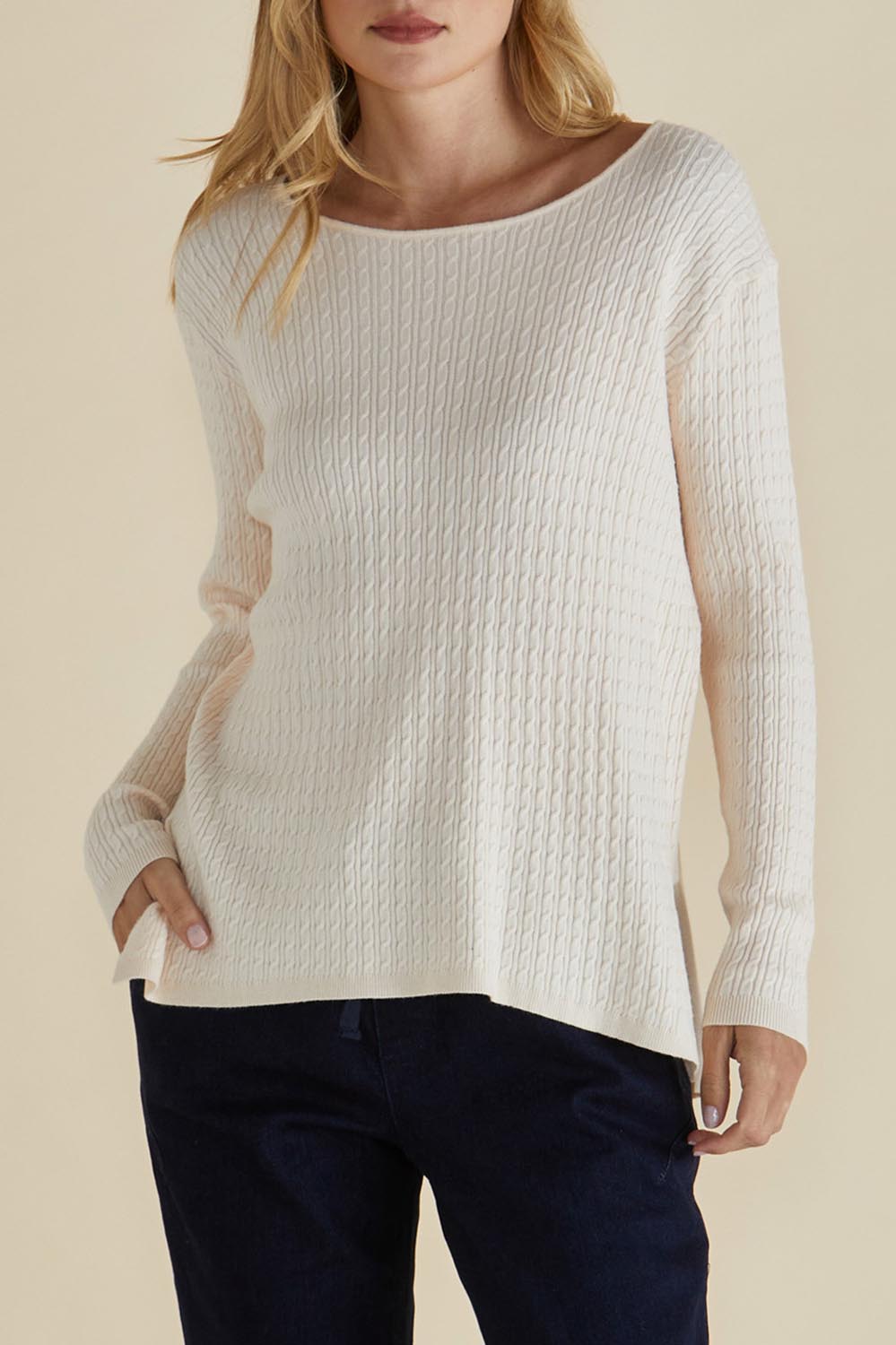 A model wearing the Cable Mini Jumper in colour Oat, from the front, cropped image