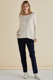 A model wearing the Cable Mini Jumper in colour Oat, from the front, showing the whole outfit