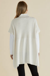 A model wearing the Paige Cotton Blend Poncho in colour Oat, from the back