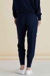 A model wearing the Aida Knit Pant in colour Navy (Blue), from the back