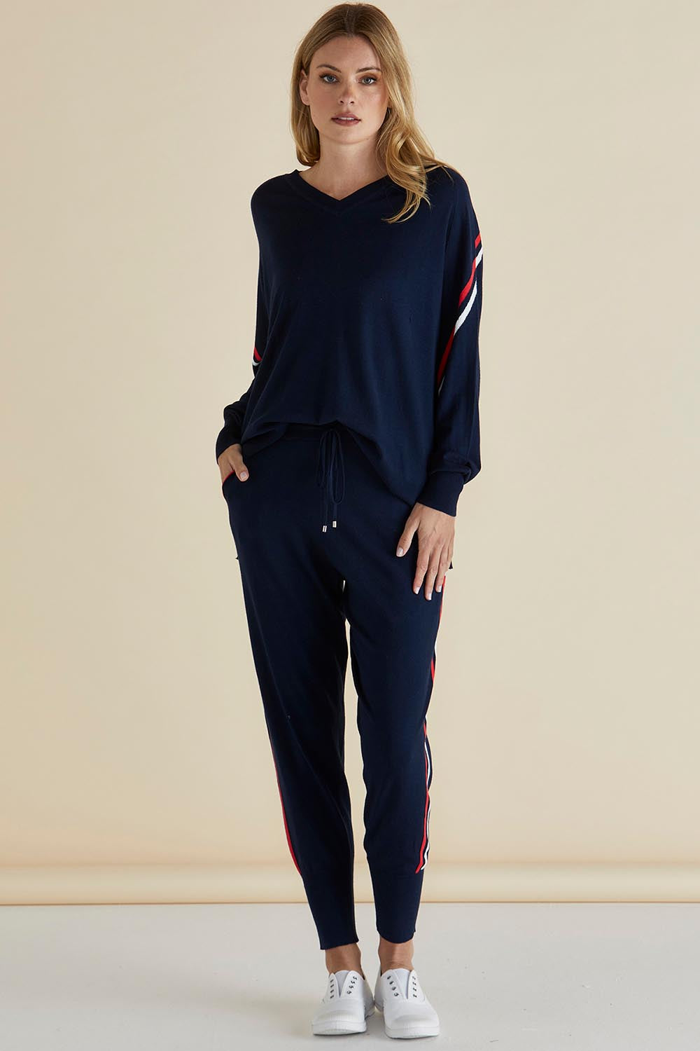 A model wearing the Aida Knit Pant in colour Navy (Blue), from the front, showing the whole outfit