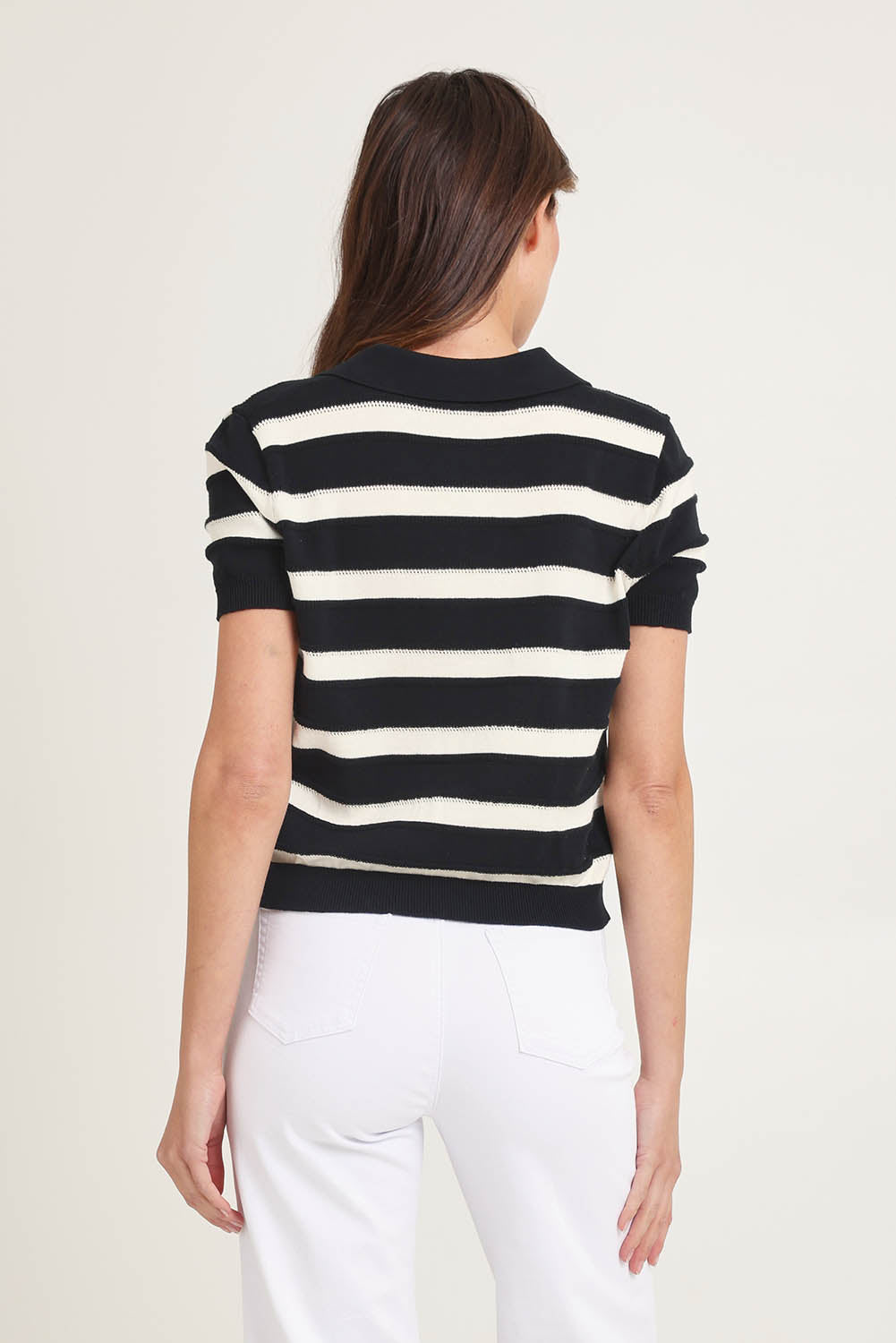 Model Madeline wearing size 10 of the Salford Cotton Knit Polo in colour Creamblk (Black), from the back