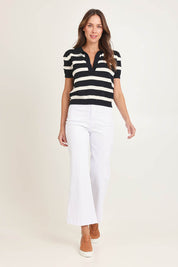 Model Madeline wearing size 10 of the Salford Cotton Knit Polo in colour Creamblk (Black), from the front, showing the whole outfit