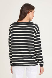 Model Madeline wearing size 10 of the Bradford Knit Top in colour Creamblk (Black), from the back
