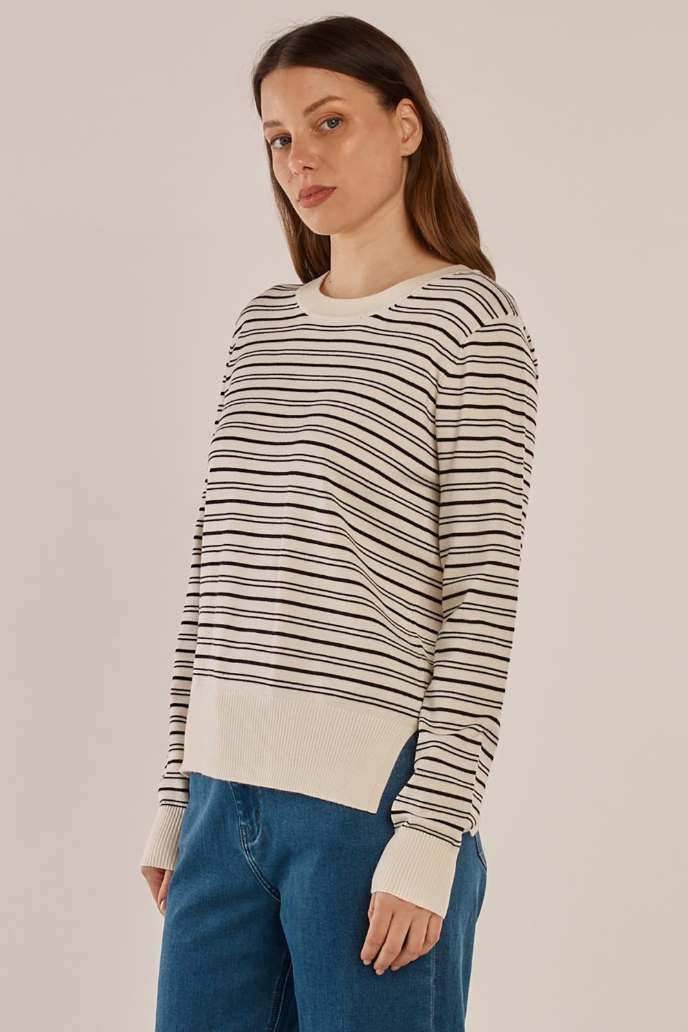 A model wearing the Louis Sweater in colour Creamblk (White), from the front, cropped image