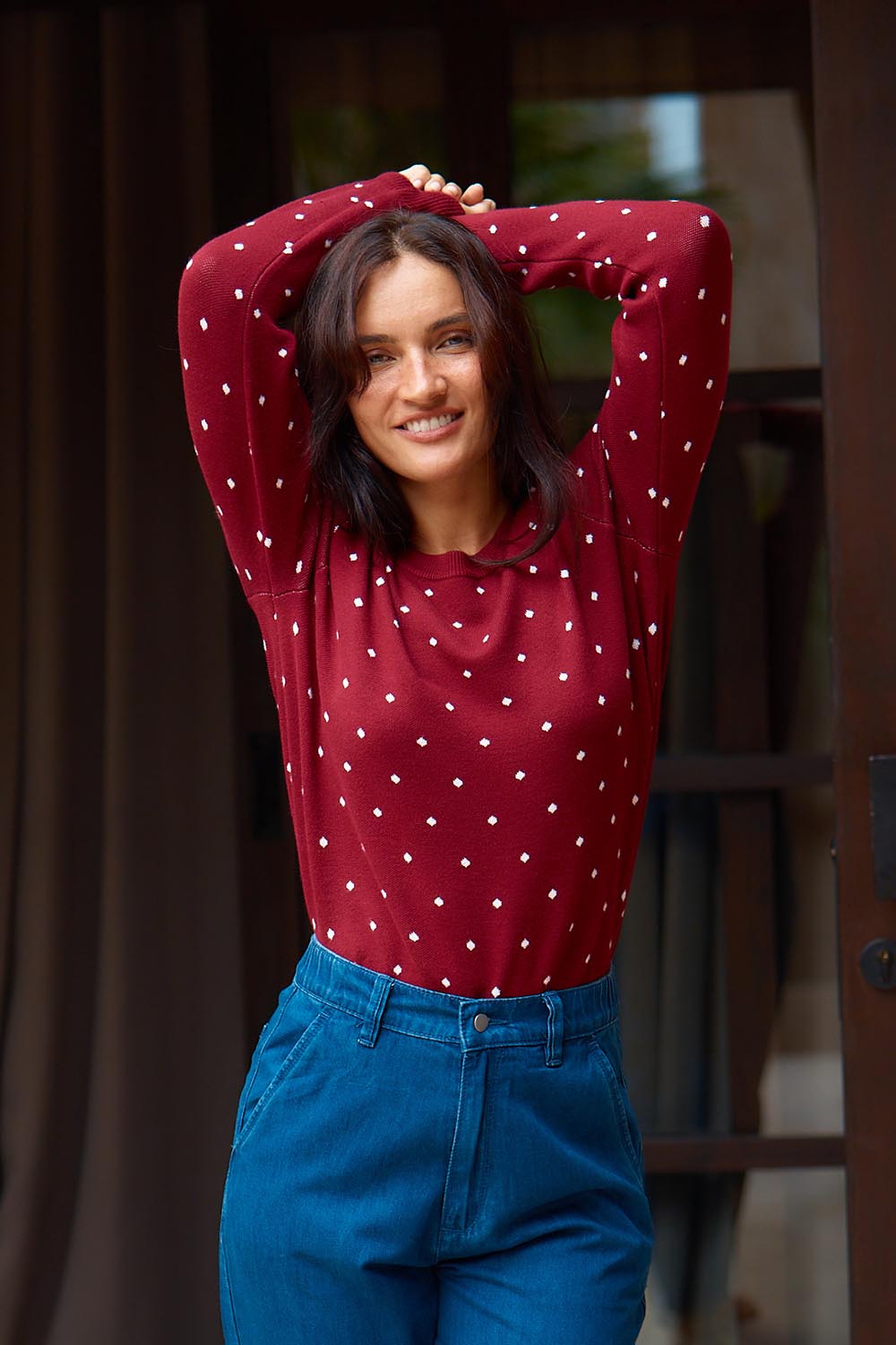 A model wearing the Louis Sweater in colour Burgandy (Red), from the front, showing the whole outfit