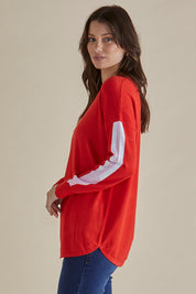 A model wearing the Sophie Knit Jumper in colour Red (Red), from the front, cropped image