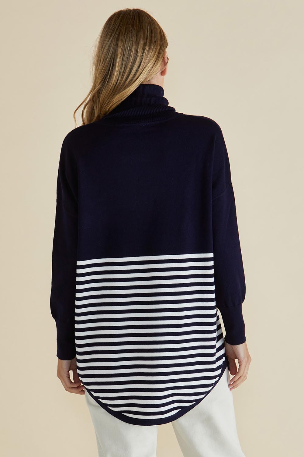 A model wearing the Fleur Roll Neck Jumper in colour Navystripe (Blue), from the back