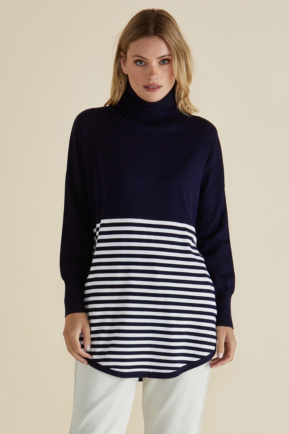 A model wearing the Fleur Roll Neck Jumper in colour Navystripe (Blue), from the front, cropped image