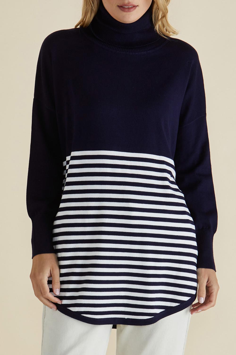 A model wearing the Fleur Roll Neck Jumper in colour Navystripe (Blue), from the front, cropped image