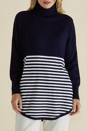 A model wearing the Fleur Roll Neck Jumper in colour Navystripe (Blue), from the front, cropped image