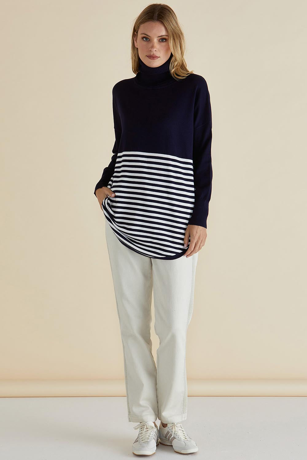 A model wearing the Fleur Roll Neck Jumper in colour Navystripe (Blue), from the front, showing the whole outfit