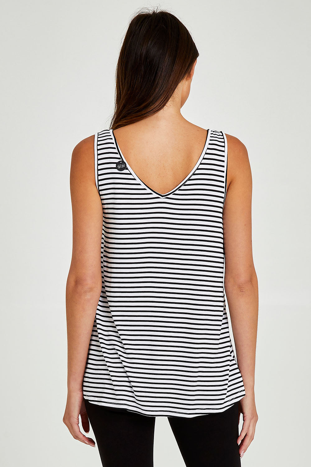 Model Madeline wearing size 10 of the Sirena Reversible Tank in colour Noirstripe (White), from the back