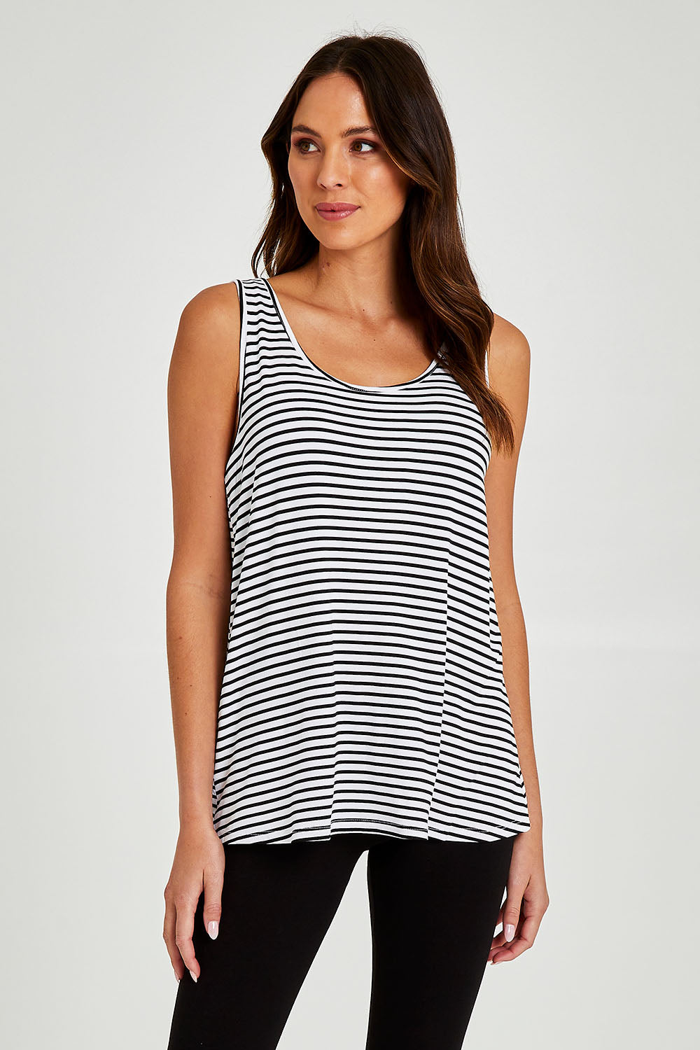 Model Madeline wearing size 10 of the Sirena Reversible Tank in colour Noirstripe (White), from the front, cropped image