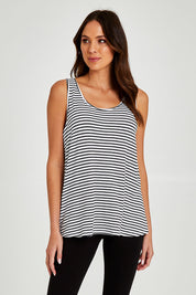Model Madeline wearing size 10 of the Sirena Reversible Tank in colour Noirstripe (White), from the front, cropped image