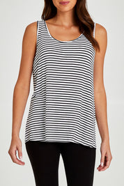Model Madeline wearing size 10 of the Sirena Reversible Tank in colour Noirstripe (White), from the front, cropped image
