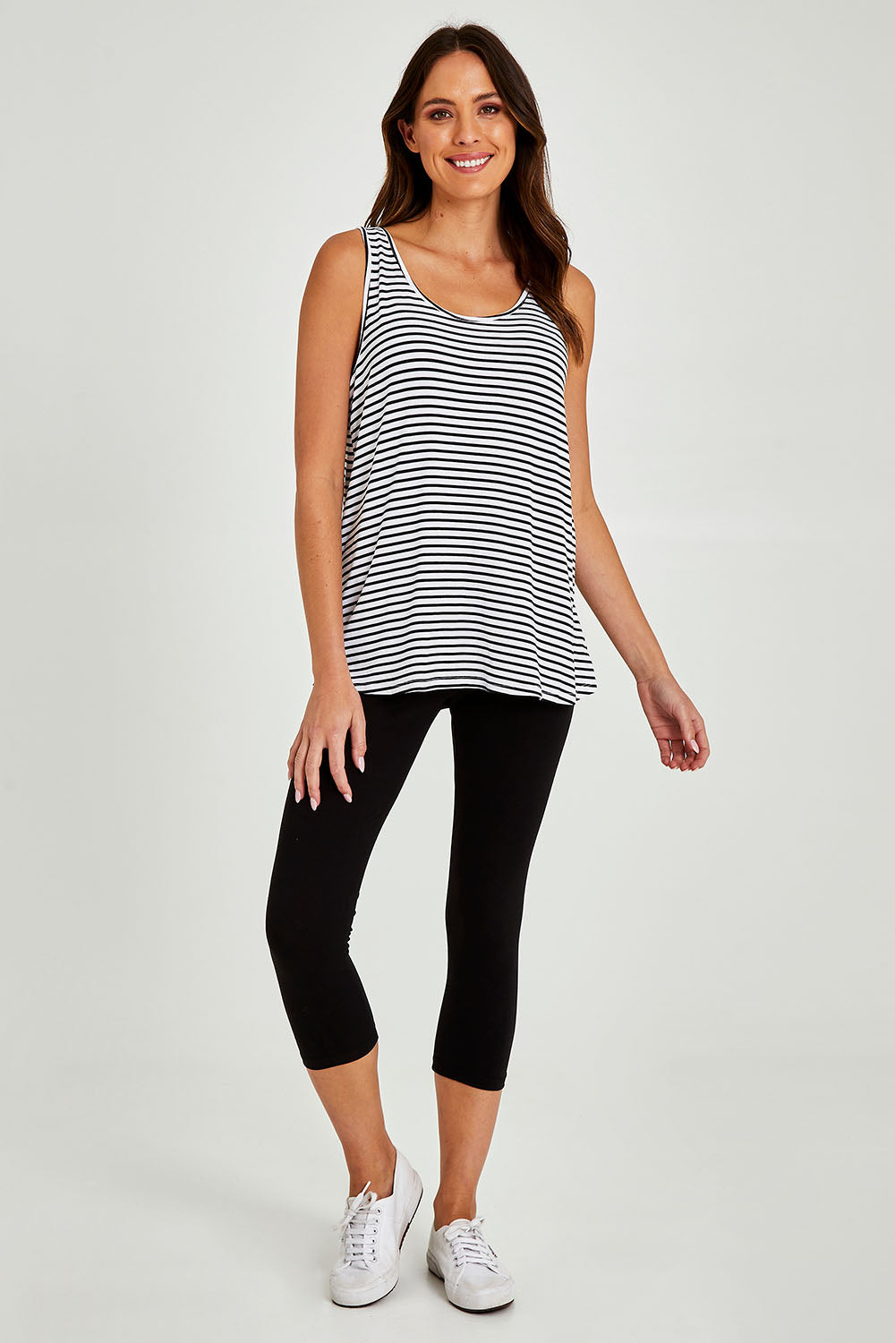 Model Madeline wearing size 10 of the Sirena Reversible Tank in colour Noirstripe (White), from the front, showing the whole outfit