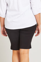 Model Poppy wearing size 16 of the Bermuda Bengaline Short in colour Black (Black), from the back