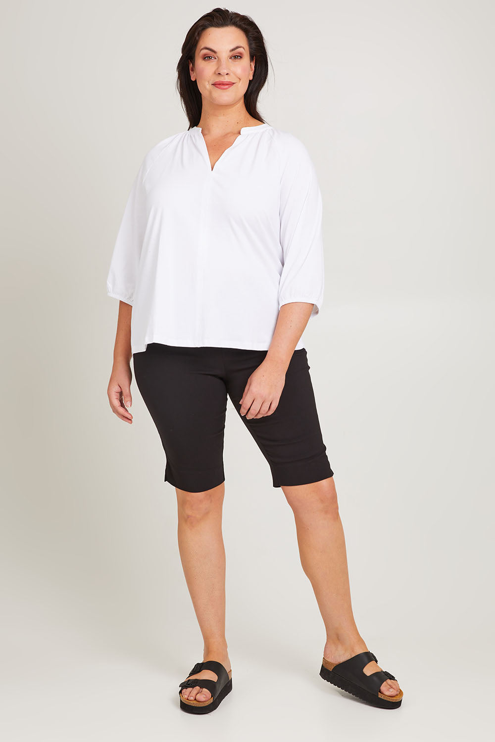 Model Poppy wearing size 16 of the Bermuda Bengaline Short in colour Black (Black), from the front, showing the whole outfit