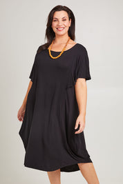 Model Poppy wearing size 16 of the Tahiti Frill Dress in colour Black (Black), from the front, cropped image