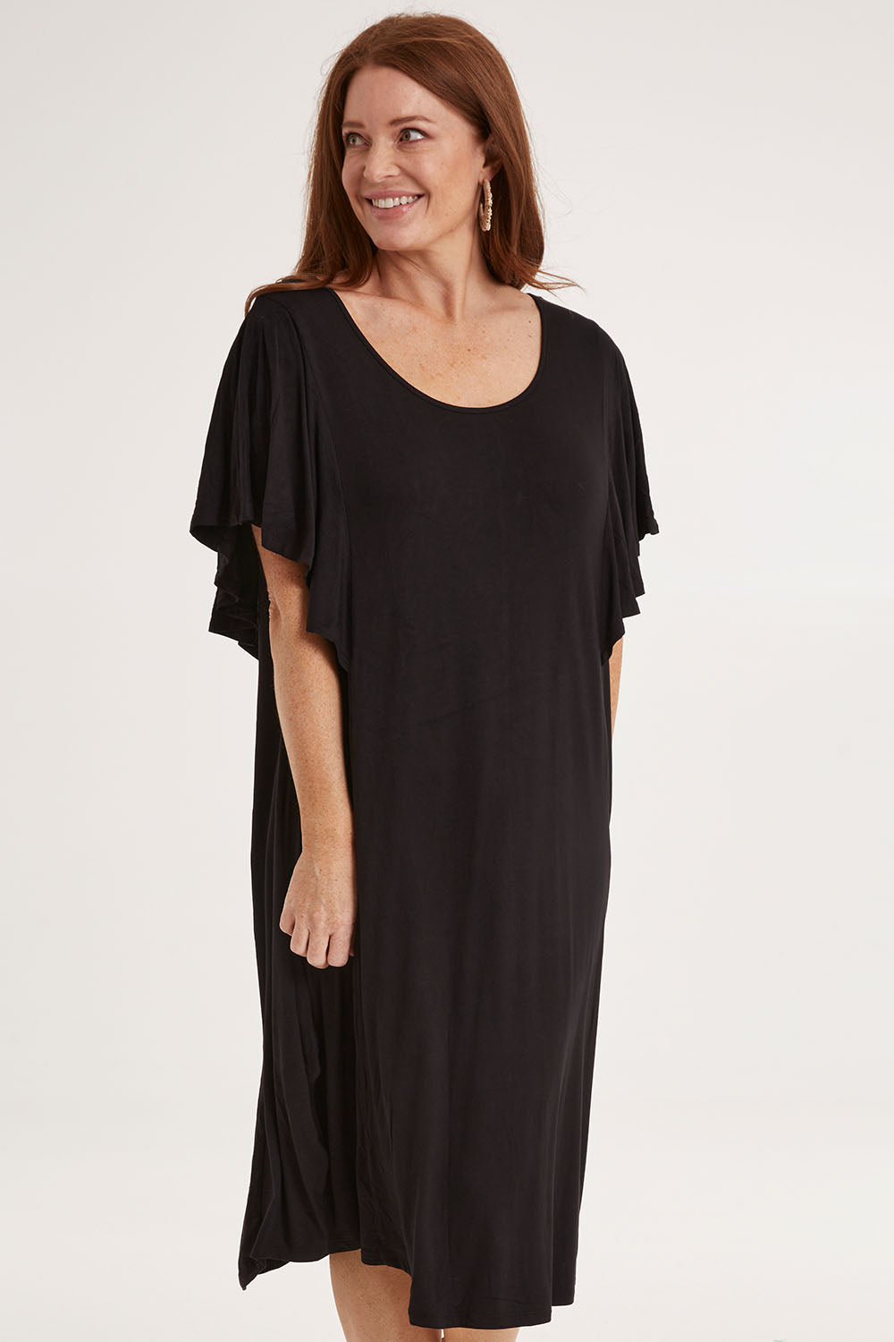 Model Sally wearing size 10 of the Tahiti Frill Dress in colour Black (Black), from the front, cropped image