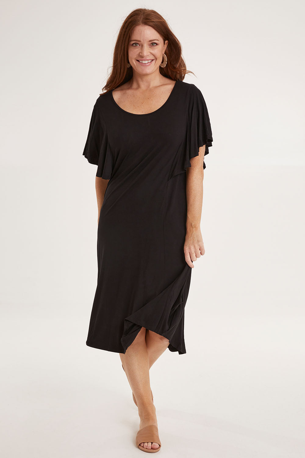 Model Sally wearing size 10 of the Tahiti Frill Dress in colour Black (Black), from the front, showing the whole outfit