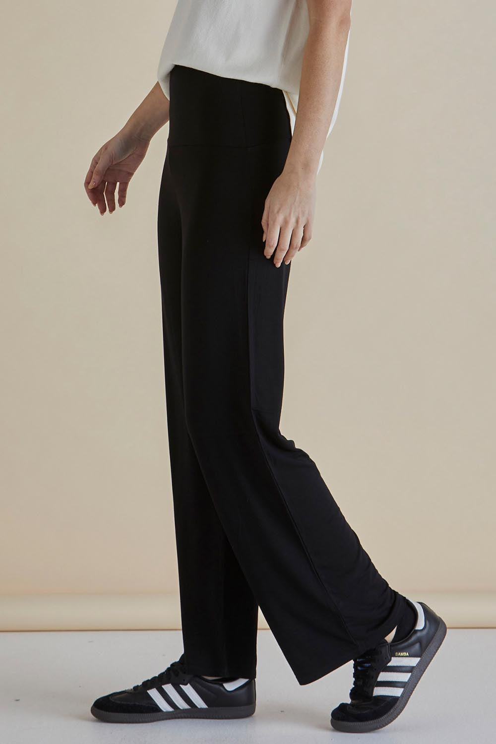 A model wearing the Houston Relaxed Pant in colour Black (Black), from the front, cropped image