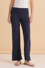 A model wearing the Houston Relaxed Pant in colour Petrol (Blue), from the front, cropped image
