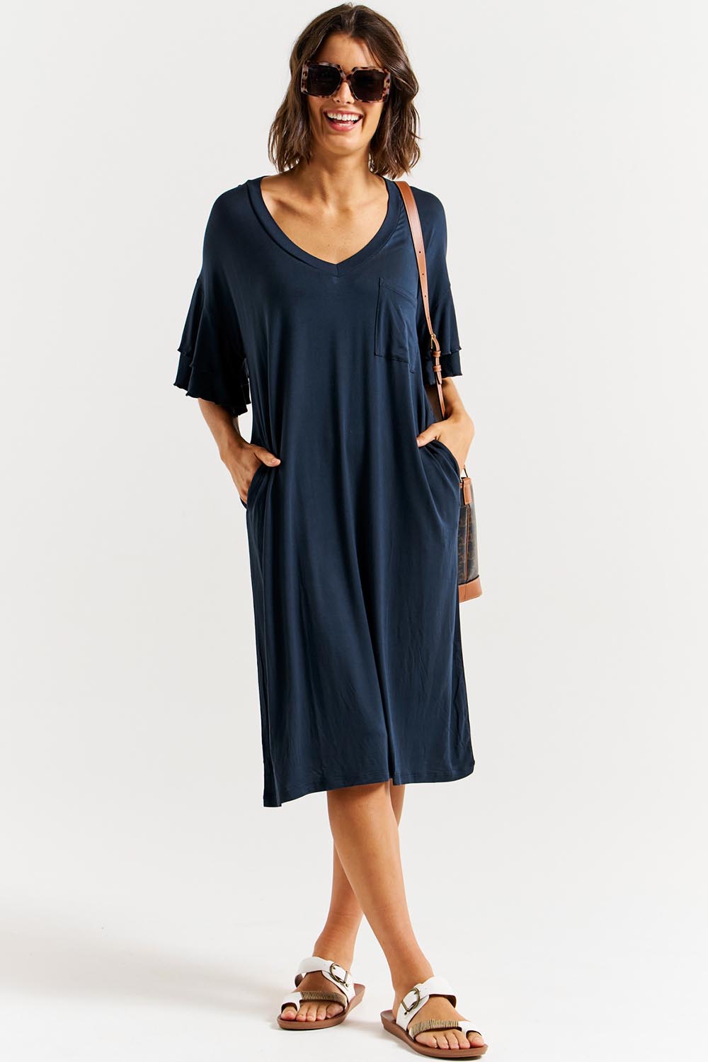 A model wearing the Mykonos Bamboo Dress in colour Petrol (Blue), from the front, showing the whole outfit