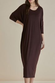 A model wearing the Melody Bamboo Dress in colour Chocolate, from the front, cropped image