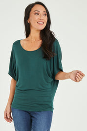 Model Katie wearing size 10 of the Maui Stretch Tee in colour Ivy (Green), from the front, cropped image