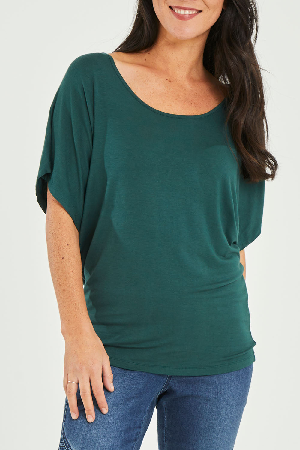 Model Katie wearing size 10 of the Maui Stretch Tee in colour Ivy (Green), from the front, cropped image