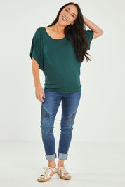 Model Katie wearing size 10 of the Maui Stretch Tee in colour Ivy (Green), from the front, showing the whole outfit