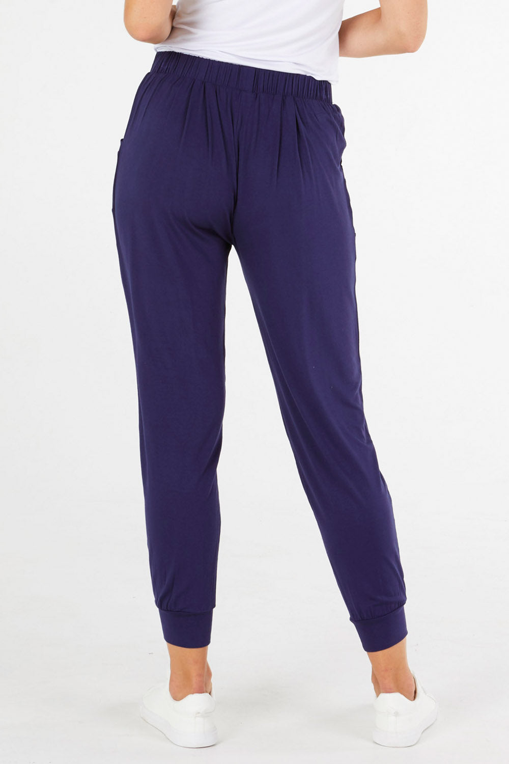 A model wearing the Paris Pant in colour Navy (Blue), from the back